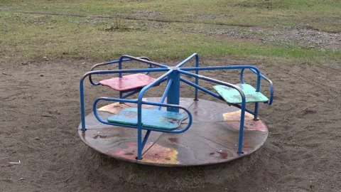 Children's rotating carousel in the park after rain. Spins without people Stock Footage 153360675