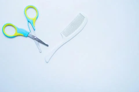 Children's scissors for cutting nails and a children's comb are on a white Stock Photos