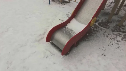 Children's slide in the playground lonely falling snow in the spring Stock Footage 175962529