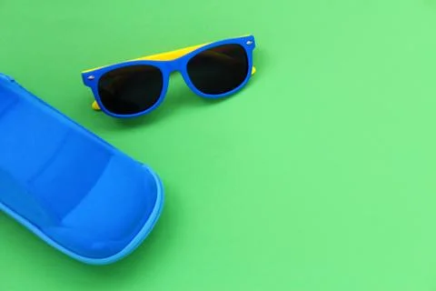 Children's sunglasses with colored frames and a blue case for glasses in the 写真素材