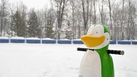 Children's support for teaching ice skating in a city park during a snowfall Stock Footage 153209310