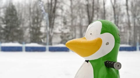 Children's support for teaching ice skating in a city park during a snowfall Stock Footage 153209594
