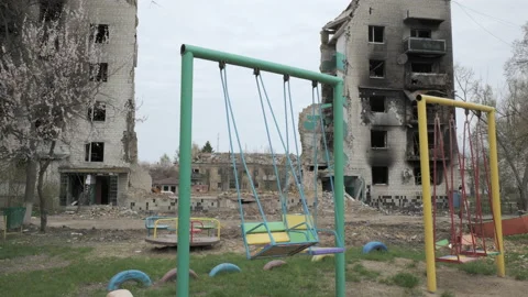 Children's swing against the backdrop of a destroyed residential building as a Stock Footage 188441440