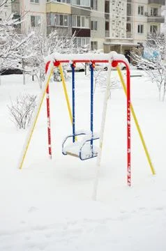 Children's swing, covered with a thick layer of snow after a heavy snowfall Stock Photos