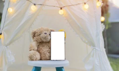 Children's time concept with teddy bear and vertical smartphone mockup with.. Stock Photos
