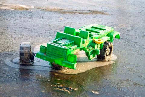 Children's, toy broken truck. The wheels froze in a pond Stock Photos