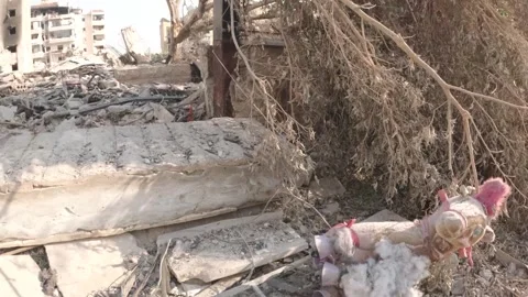 A children's toy torn on the rubble of destroyed buildings in the southern s Stock Footage 289846463
