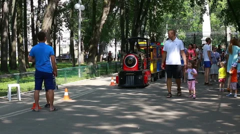 Children's train goes throu crowd of people (Editorial) Stock Footage 65431211