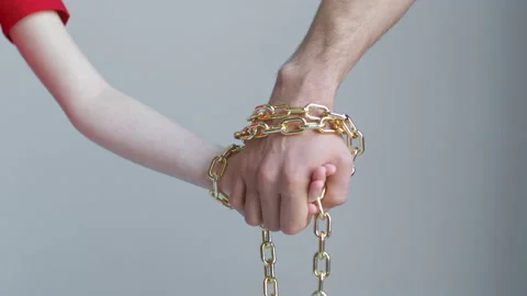 A child's and a man's hands are tied with a golden chain and do not let go Stock Footage 170544880