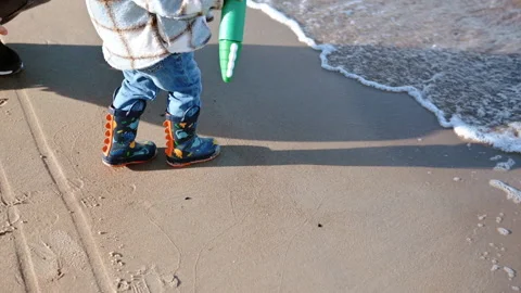 Child’s Boots Walking on Sandy Seashore Close-Up Stock Footage 307312445