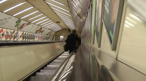 Child's eye level point of view travelling down escalator to underground Stock Footage 1100138