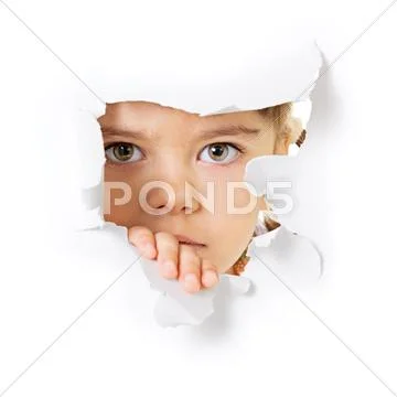 Child's face looking through a hole in paper Stock Photos
