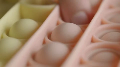 Child's finger playing with a pop it fidget toy in close-up shot Stock-Footage 341416213