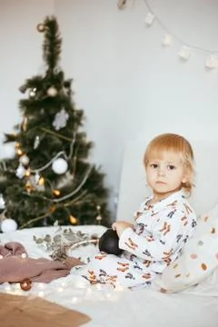 The child's first Christmas. a pensive little boy is lying in his holiday pyj Stock Photos