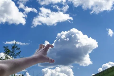 Child's hand arranges clouds in sky. concept of cloud computing Stock Photos