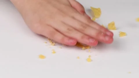 Child's hand breaks chips. On white background. Stock Footage 146404897