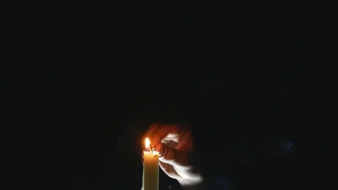 Child's hand with a burning match lights a candle Stock Footage 104988254
