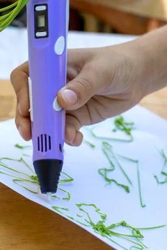 Child's hand creates figures with a 3D pen. Close-up Stock Photos