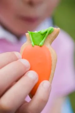 Child's hand holding Easter biscuit with bite taken Foto stock