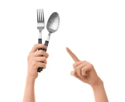 Childs hand holding silver fork and spoon with black handles, pointing finger Stock Photos
