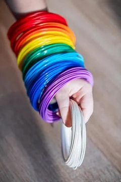 A child's hand holds a multi-colored plastic for creativity. Stock Photos