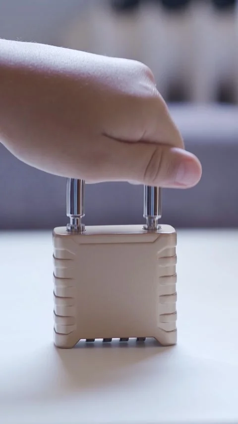 Child's hand locking a combination padlock for security Stock Footage 341324373