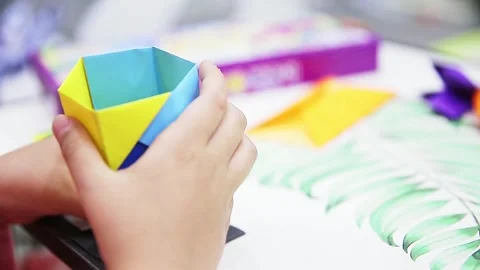 A child's hand making a work of colored paper Video stock 295497730
