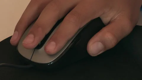 Child's hand moving a computer mouse on top of a black mouse pad. Stock Footage 249044788