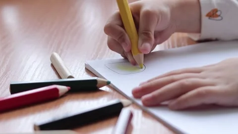 Child's hand with a pencil close-up, selective focus. Girl draws a picture Stock Footage 253428985
