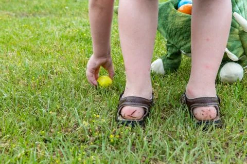 Child's hand picking up easter eggs Stock Photos