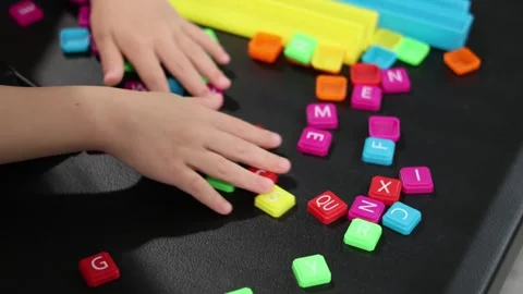 Childs hand playing with letter blocks. San Francisco CA USA May 10 2026 Stock Footage 336296058