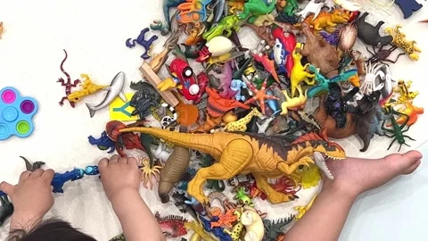 A child's hand playing with various small toys Stock Footage 197932734