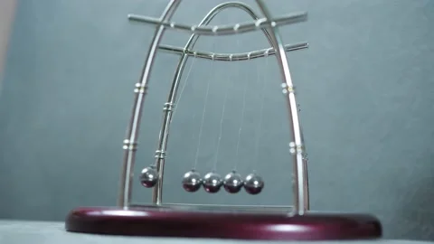 A child's hand plays with a pendulum newton's balls Stock Footage 146735731