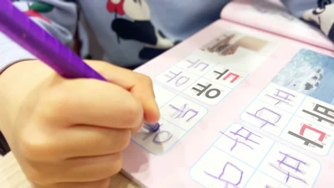 A child's hand practicing writing in Korean Video stock 296172224