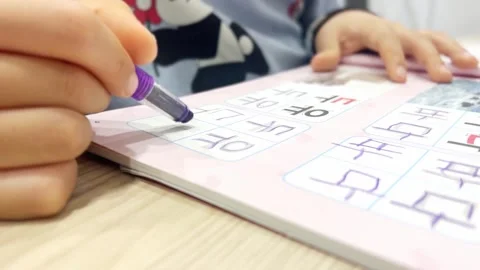 A child's hand practicing writing in Korean Stock Footage 296172225