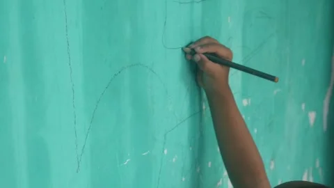 A Childs hand scribbles on a green wall Stock Footage 324941377