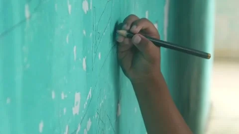 A Childs hand scribbles on a green wall Stock Footage 324941384