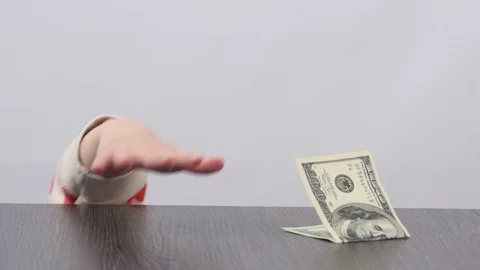 Child's hand showing from under the table and steals banknote. Child steals cash Stock Footage 72850049