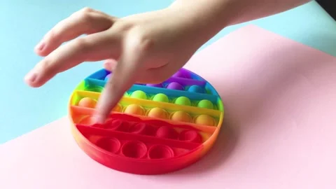 A child's hand snaps the pimples of a pop it toy. Stock Footage 154707836