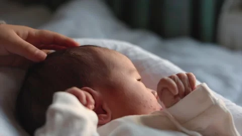 Child's hand stroking the head of a newborn. Siblings relationship. Parenthood Stock Footage 190883182