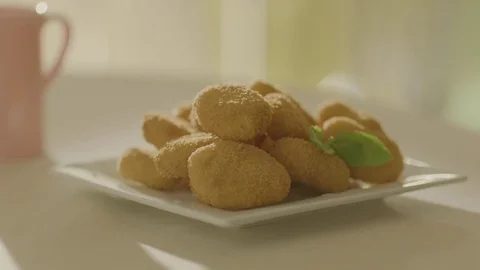 The child's hand takes an appetizing nuggets from the plate. Stock Footage 83723141