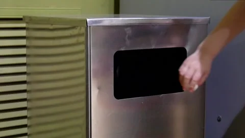 A child's hand throws a crumpled piece of paper into the trash can close-up Stock Footage 154986655