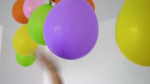 Child's hand touching a hanging balloon Vidéo 220511165