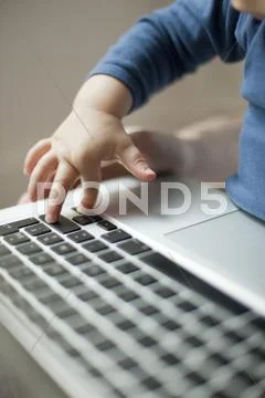 Child's Hand Touching Laptop Keyboard