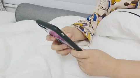 A child's hand using a smartphone in bed Video stock 301783806