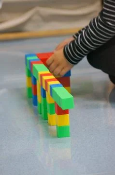 A child's hands building a structure using colorful blocks. This scene high.. Stock Photos