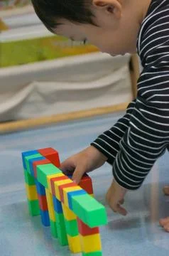 A child's hands building a structure using colorful blocks. This scene high.. Stock Photos