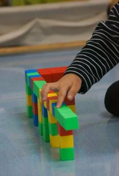 A child's hands building a structure using colorful blocks. This scene high.. Stock Photos