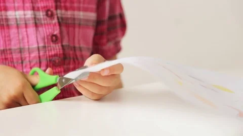 Child's hands cutting paper with scissors Stock Footage 76689304