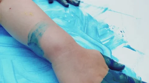 The child's hands during spontaneous painting with water-soluble paints on a Stock Footage